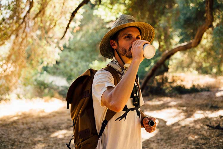 Conseil : gérer la canicule en randonnée. Randonneur faisant une pause pour boire de l'eau. Crédit : HEMIS