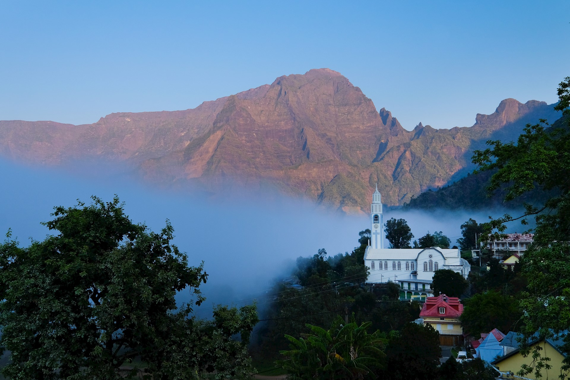 GR R2 Réunion, l'église de Cilaos au lever du soleil, au fond le Grand Bénare, crédit photo : Johannes Braun